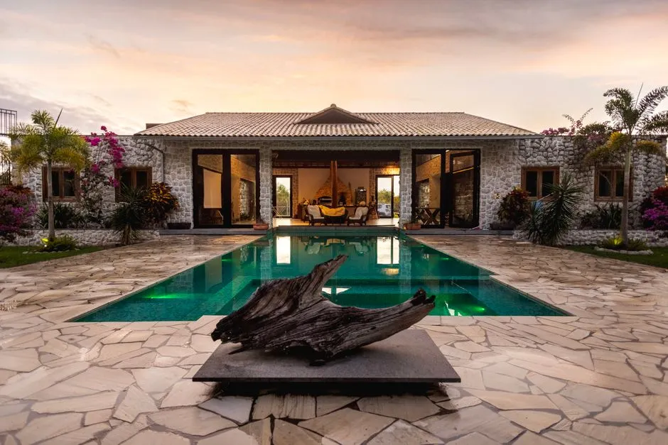 Villa tropicale avec piscine au coucher du soleil, illustrant un bien immobilier destine a la location