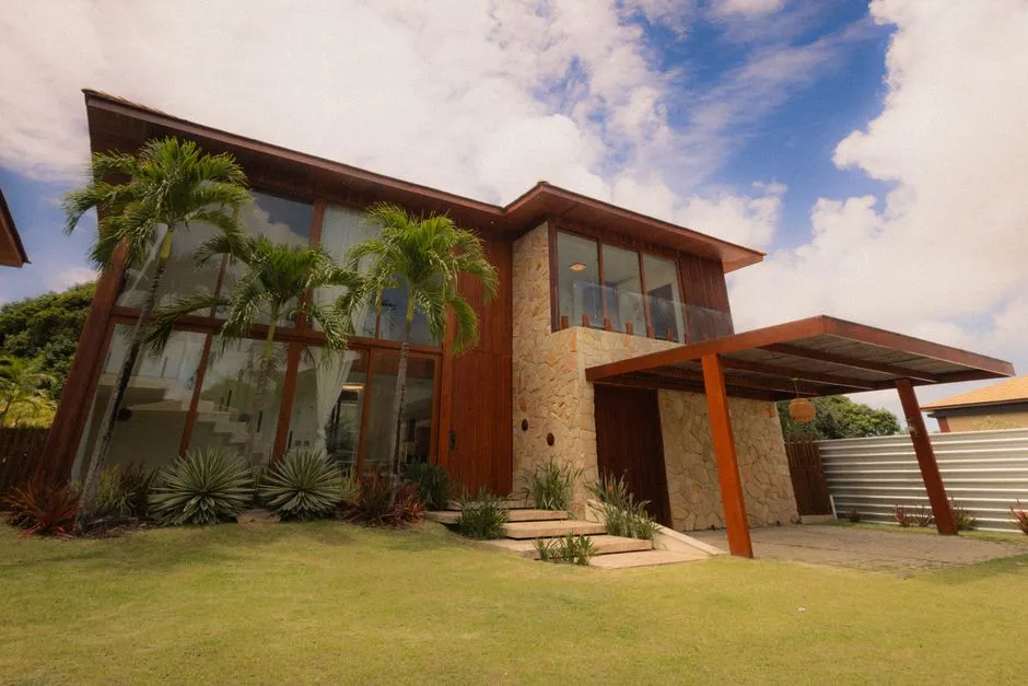 Maison moderne de standing entouree de palmiers et de pelouse, type de bien recherche pour l'investissement locatif en zone tropicale