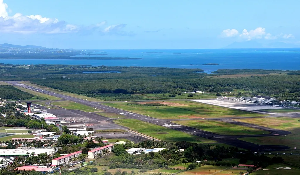 Vue aerienne de l'aeroport de Pointe-a-Pitre Le Raizet aux Abymes, avec sa piste et l'aerogare bordant la mer en Guadeloupe