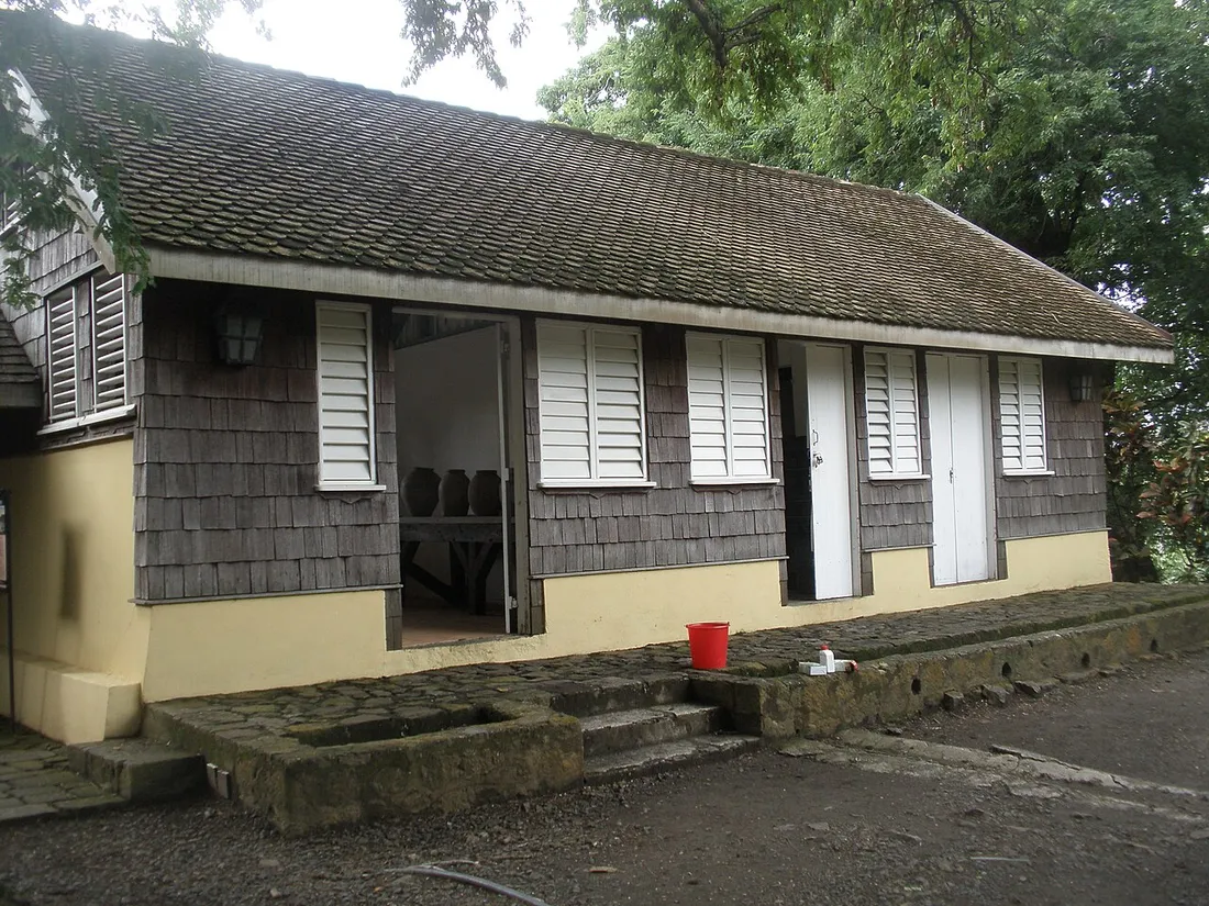 Case créole traditionnelle aux bardeaux de bois et volets blancs, en Martinique