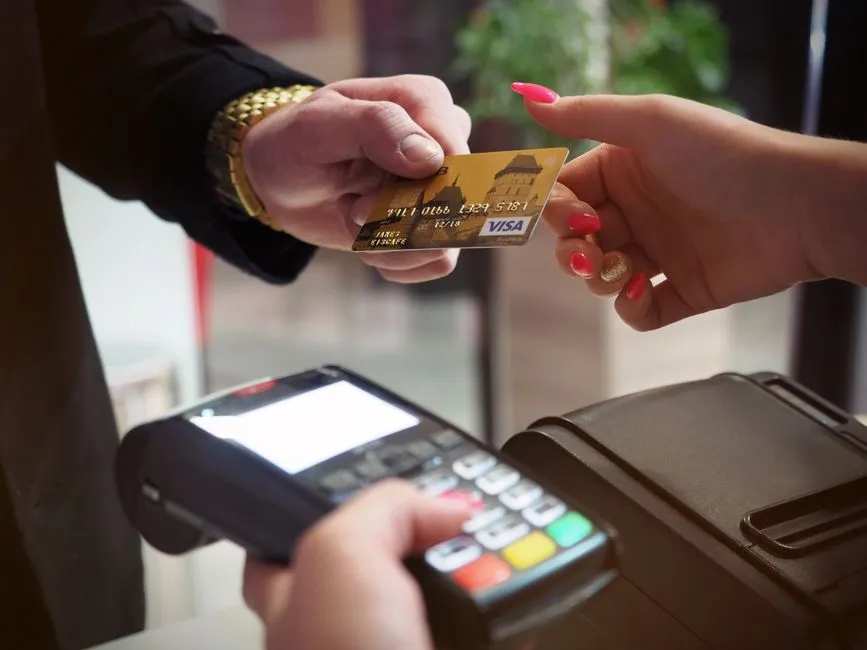 Paiement par carte bancaire Visa sur un terminal de paiement electronique, illustrant l'usage de la carte et les frais bancaires en Martinique