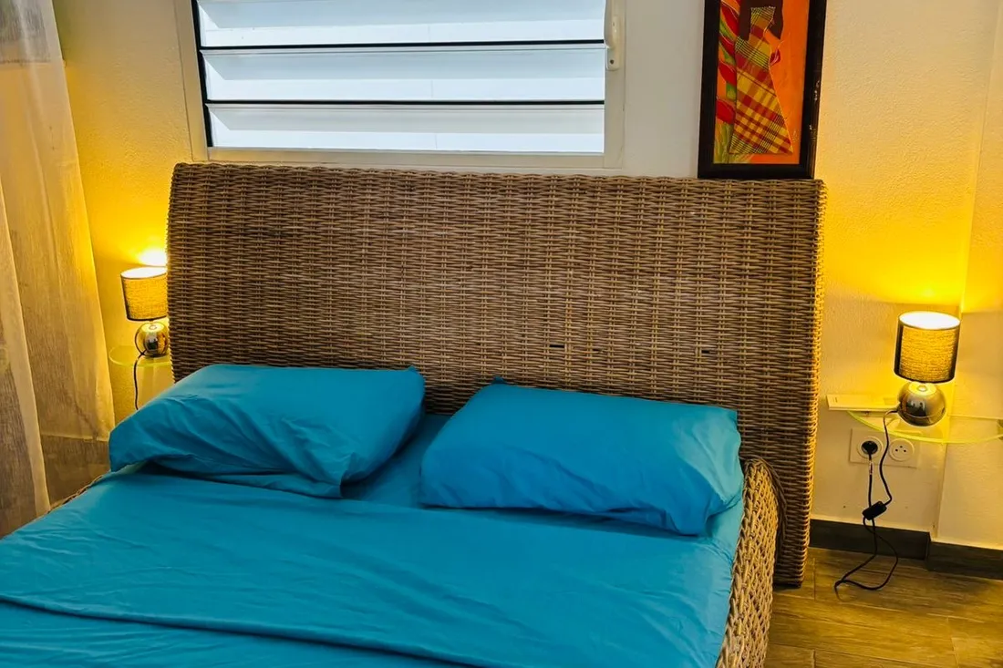 Chambre de la maison Tropikana à Rémire-Montjoly avec lit double et linge bleu