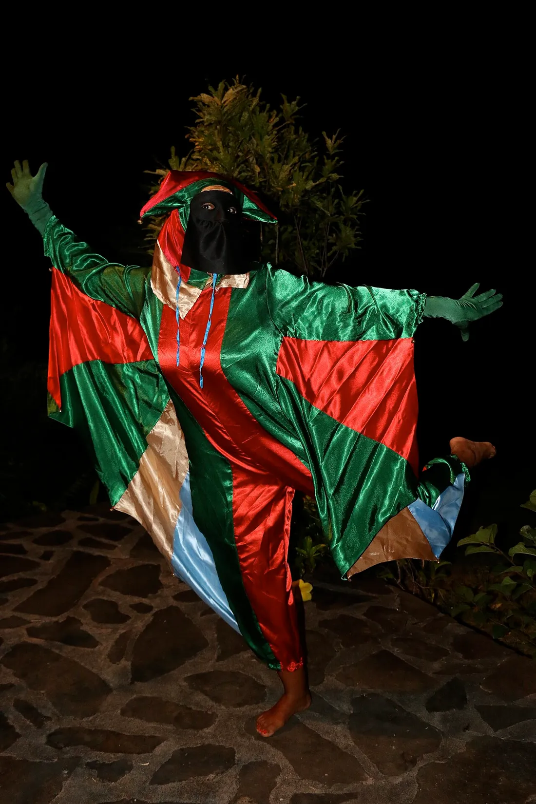 Touloulou en costume traditionnel intégral et masque noir dansant lors du carnaval de Guyane