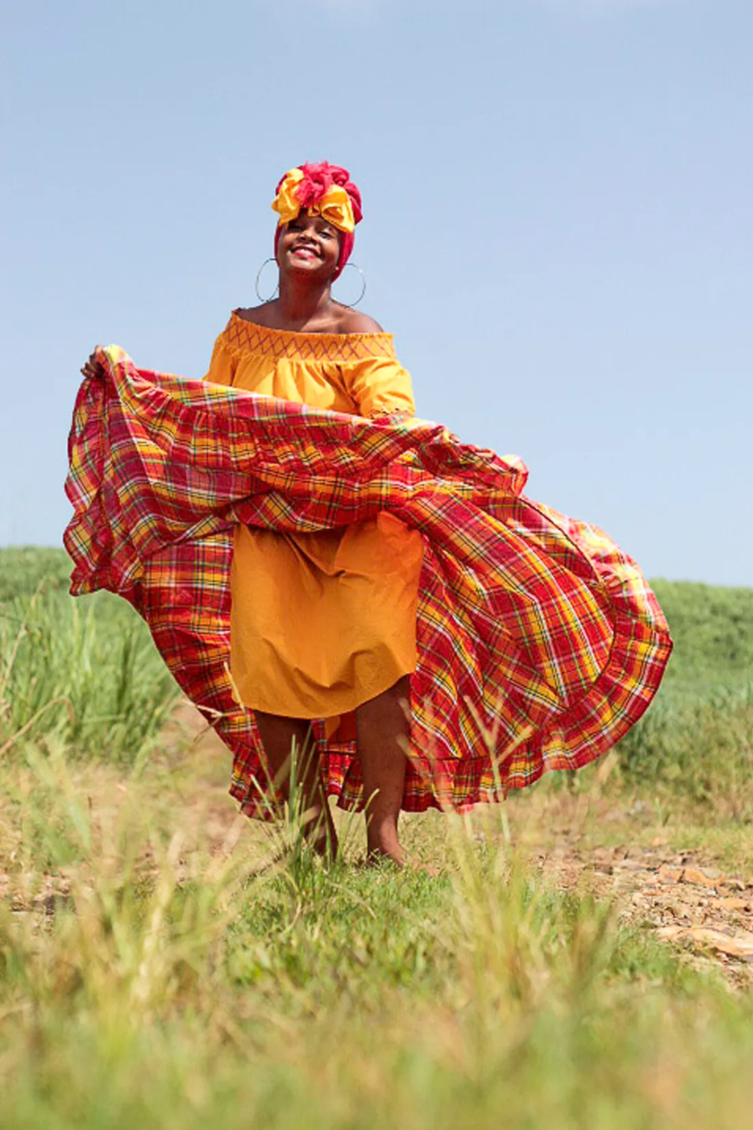Danseuse de bele en robe et coiffe madras déployant sa jupe lors d'une danse traditionnelle de Martinique