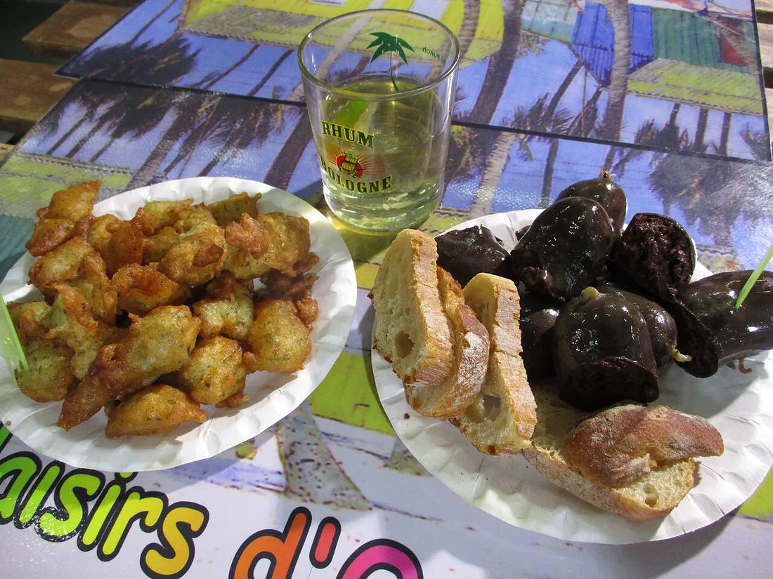 Gros plan sur des boudins creoles noirs coupes, servis avec du pain et des accras dores en Martinique