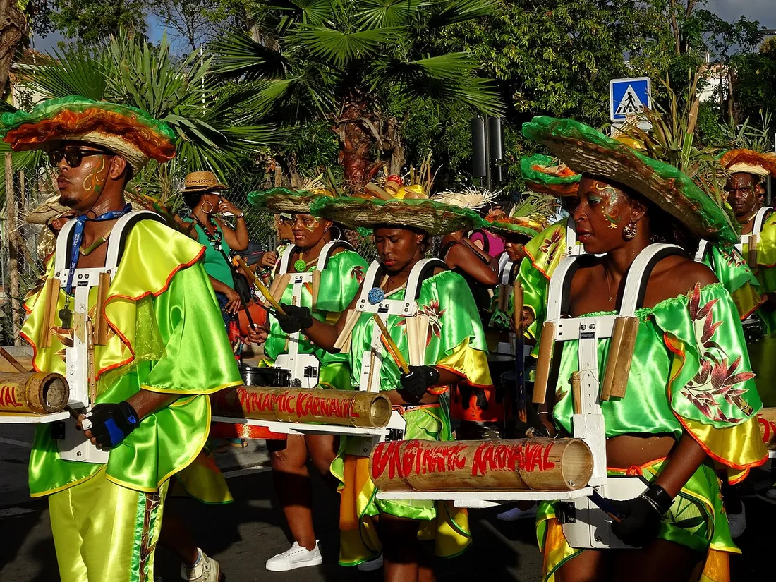 Groupe de musiciens en costumes verts et jaunes defilant a pied dans les rues de Fort-de-France pendant le carnaval de Martinique, dimanche gras