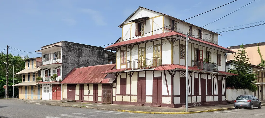 Maisons créoles traditionnelles à colombages et balcons dans une rue de Cayenne, en Guyane