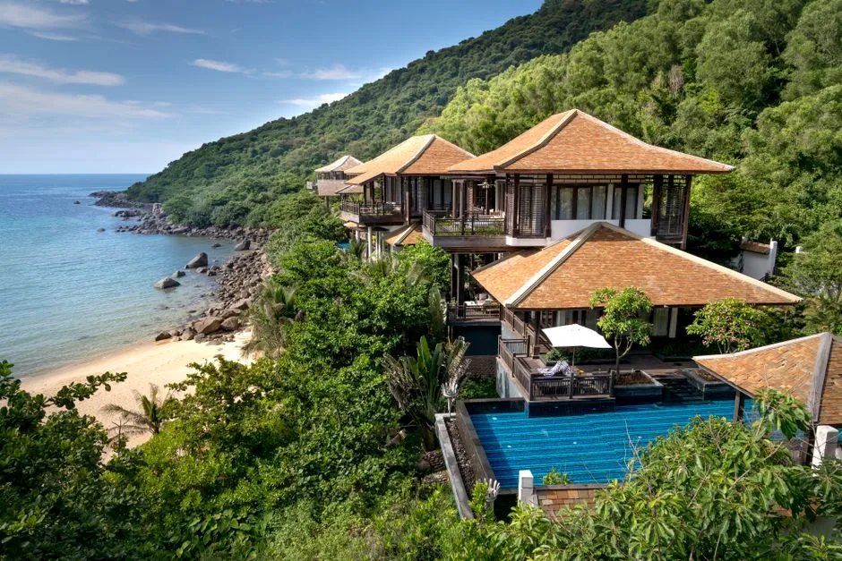 Villa de vacances avec piscine à débordement surplombant une plage tropicale, illustrant un bien à gérer et rentabiliser en location