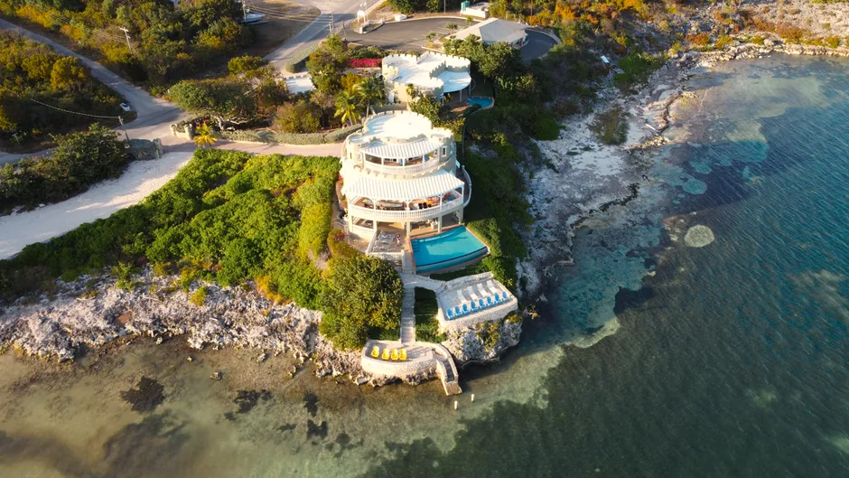 Vue aérienne d'une villa de bord de mer avec piscine privée sur une pointe rocheuse aux Caraïbes