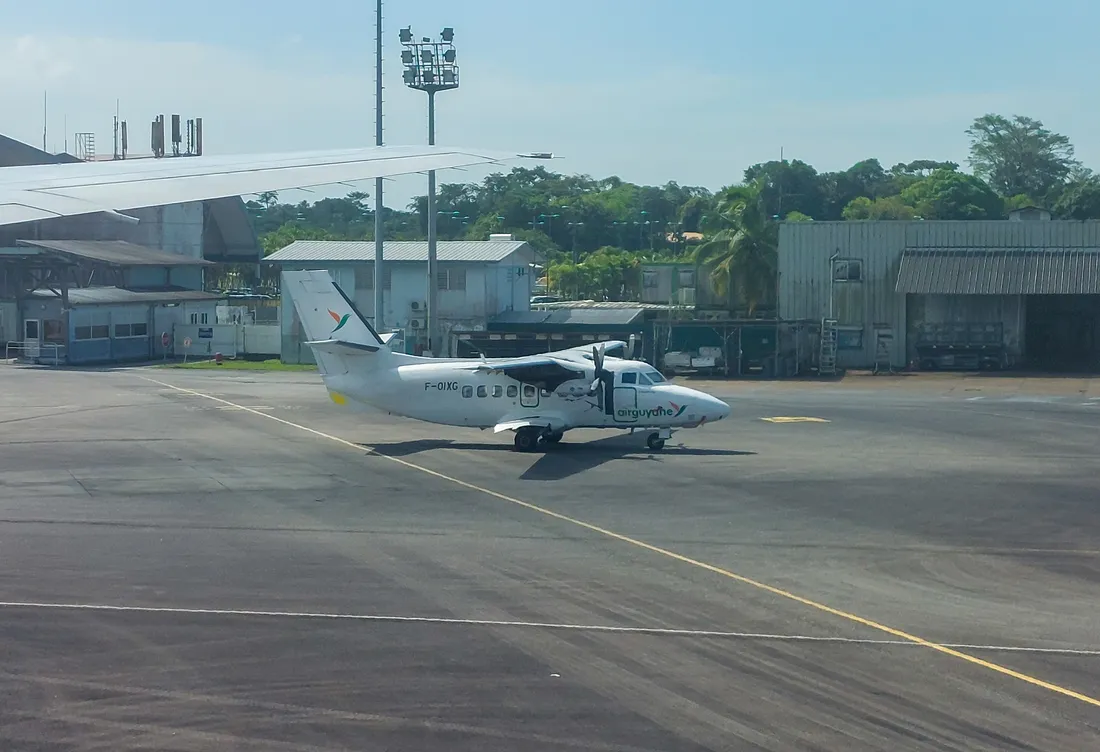 Avion regional Air Guyane stationne sur le tarmac de l'aeroport de Cayenne-Felix-Eboue a Matoury, devant les hangars et la foret guyanaise