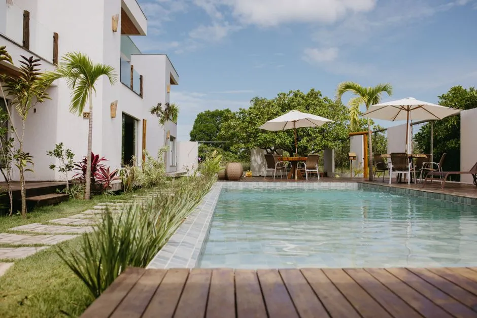 Villa de vacances avec piscine, terrasse en bois et parasols, type de bien confie a une conciergerie en Guadeloupe