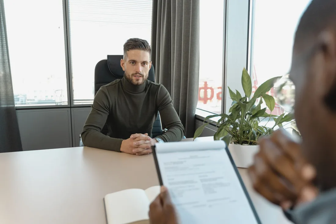 Candidat en entretien assis à un bureau dans un cadre professionnel