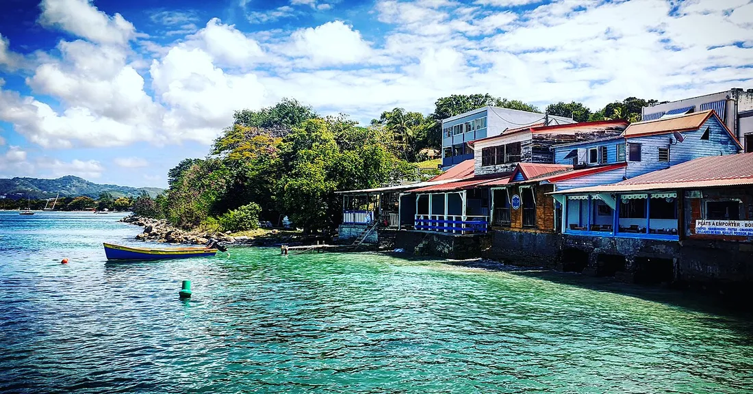 Maisons colorées du bourg de Sainte-Anne au bord de l'eau turquoise en Martinique, communes concernées par l'enregistrement des meublés de tourisme