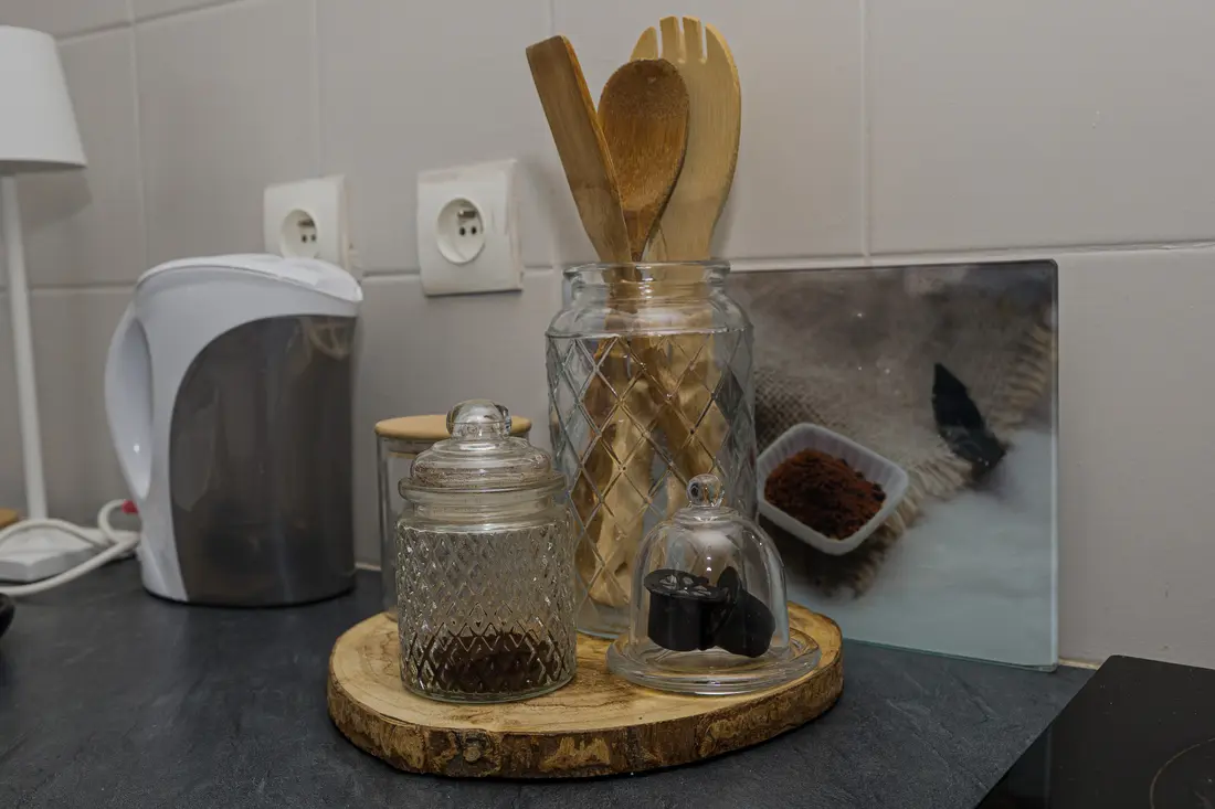 Plateau café du Cocon Cayennais : bocaux en verre, ustensiles en bambou et bouilloire sur plan gris