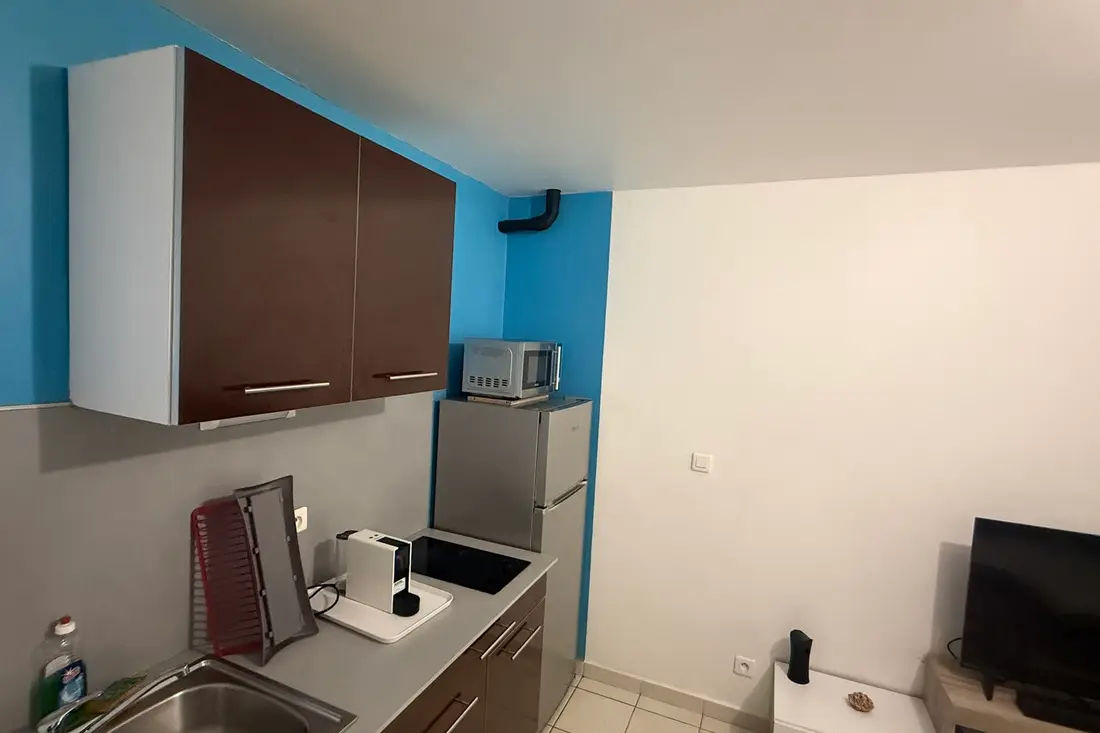 Kitchenette bleue et chocolat du Diamant Cayennais : évier inox, cafetière, plaques et réfrigérateur sous le micro-ondes