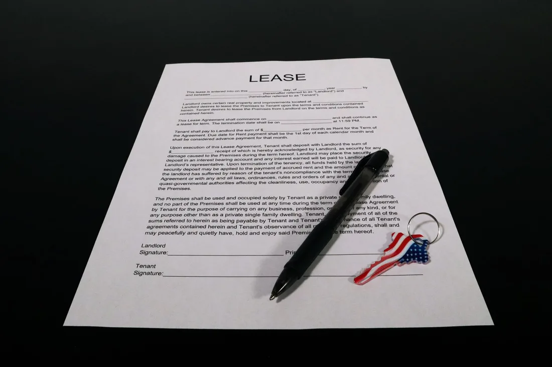Document contractuel et stylo posés sur une table sombre