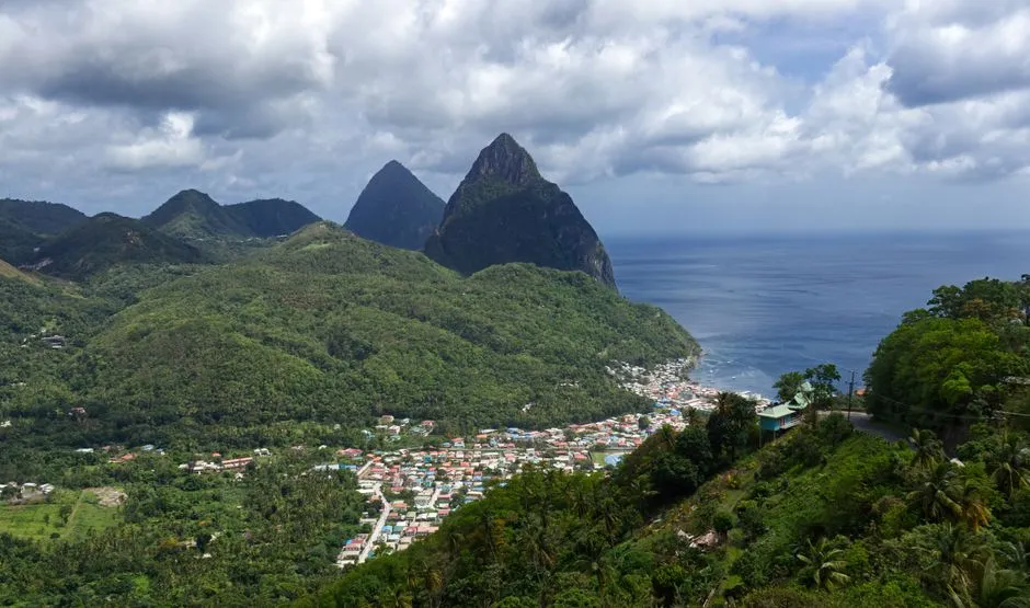 Les deux Pitons de Soufrière à Sainte-Lucie dominant la ville et la mer des Caraïbes, vue typique d'une excursion vers l'île voisine de la Martinique