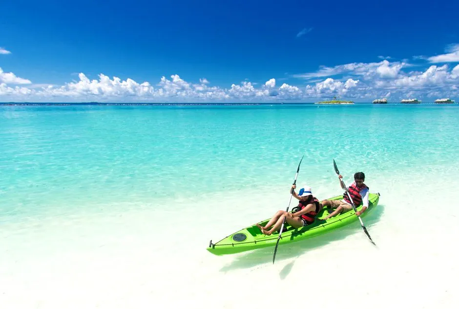 Deux personnes en kayak de mer sur une eau turquoise tropicale, evoquant l'excursion en kayak vers le Rocher du Diamant
