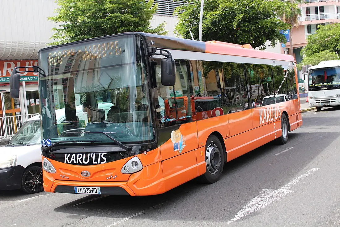 Bus orange du réseau de transport public Karu'Lis à l'arrêt dans une rue de Guadeloupe