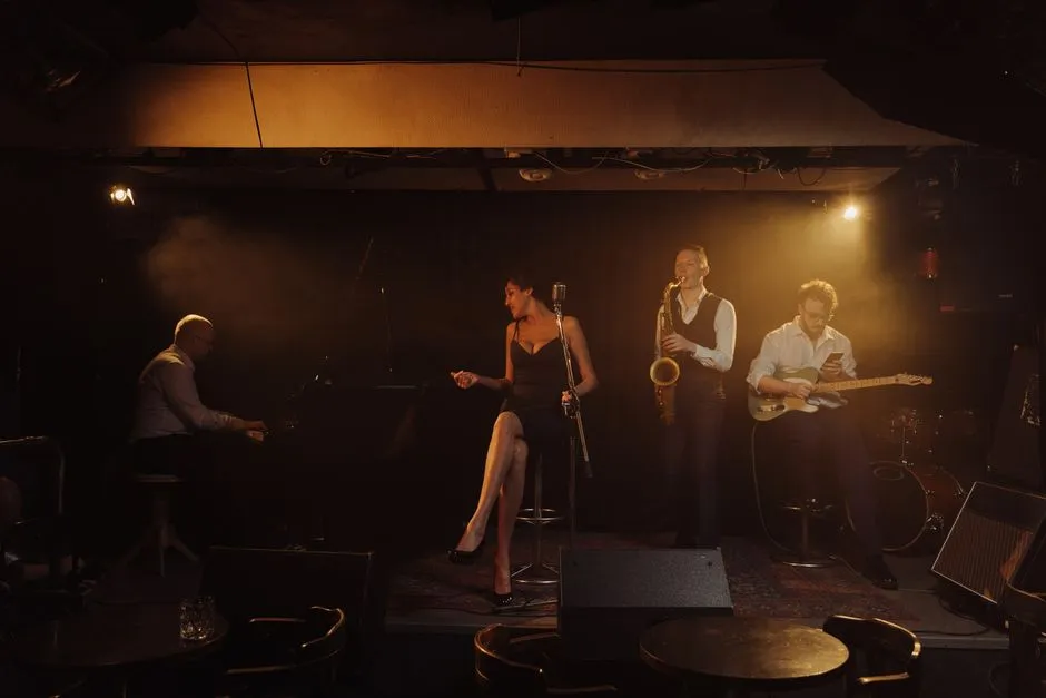 Quartet de jazz en concert sur scene, chanteuse, saxophoniste, pianiste et guitariste, ambiance festival