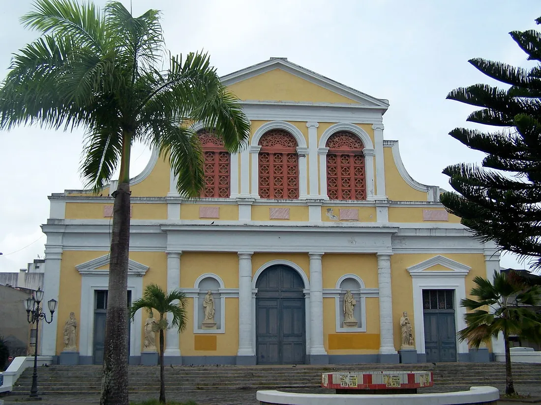 Façade de la cathédrale Saint-Pierre-et-Saint-Paul de Pointe-à-Pitre en Guadeloupe, encadrée de palmiers, lieu de la messe de la Fête des Cuisinières