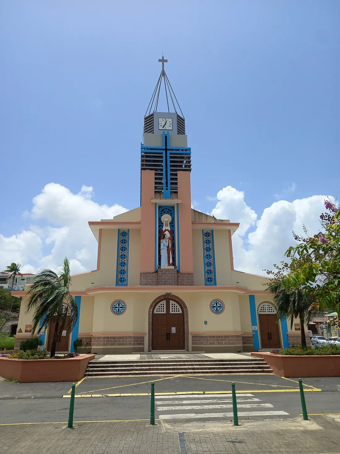 Eglise catholique Sainte-Anne de Sainte-Anne en Guadeloupe, lieu de la fete patronale, avec sa facade creme et bleue et la statue de sainte Anne au-dessus du portail