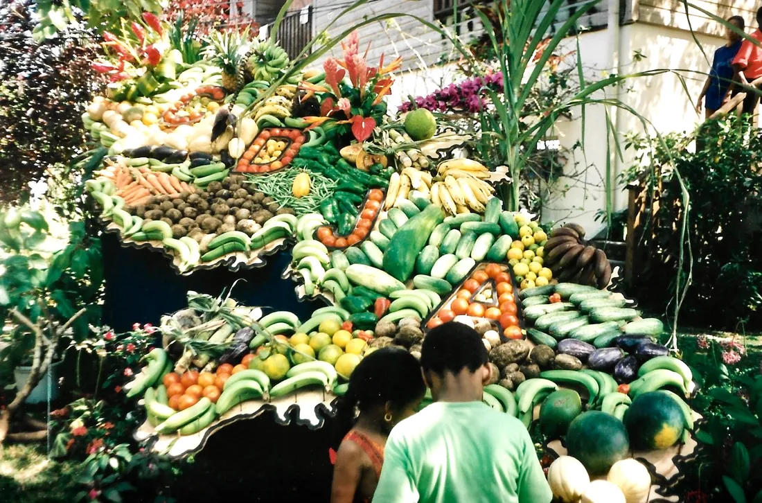 Étal abondant de fruits et légumes tropicaux au marché du Lorrain, en Martinique : bananes, plantains, christophines, agrumes et fruits de saison