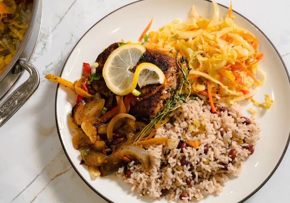 Assiette de cuisine créole avec poisson grillé, riz aux pois rouges, légumes et chou émincé, illustrant une expérience culinaire créole