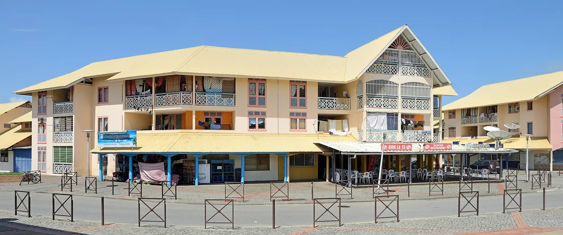 Immeubles de logements collectifs recents avec commerces en rez-de-chaussee dans un bourg amenage du littoral guyanais