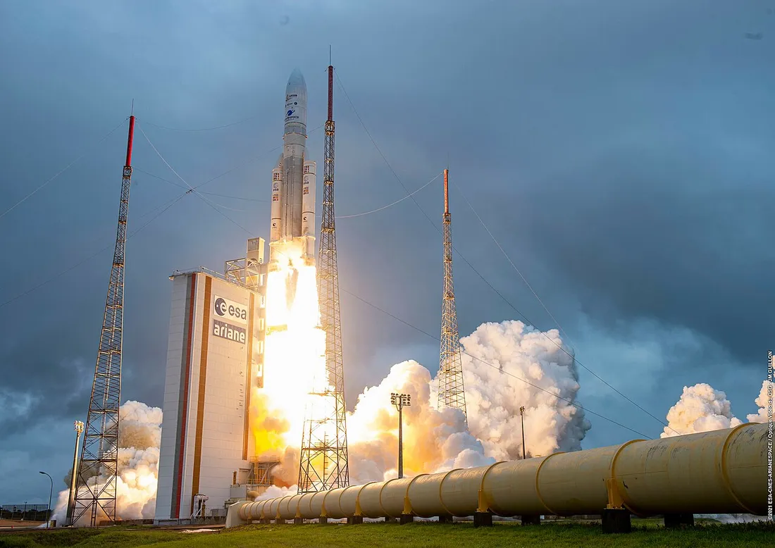 Décollage d'une fusée Ariane 5 depuis le Centre Spatial Guyanais à Kourou, flammes et panache de fumée au pied du pylône de lancement de l'ESA