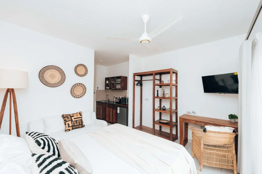 Studio meublé d'appart-hôtel avec kitchenette équipée, lit double, penderie ouverte et bureau, adapté à un séjour longue durée