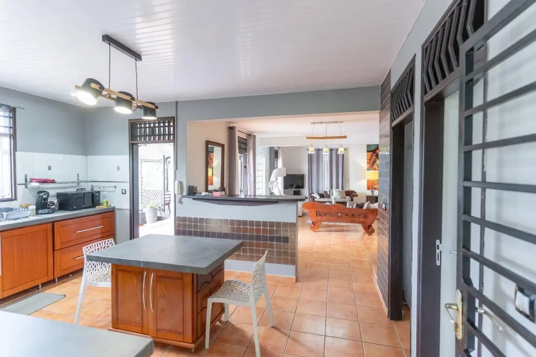 Cuisine ouverte et pièce à vivre de la Casa Belas Artes à Cayenne, îlot central et carrelage terracotta