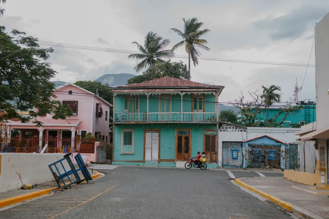 Maisons créoles en bois aux façades colorées dans un quartier résidentiel des Antilles, illustrant un bien locatif susceptible de tomber en indivision