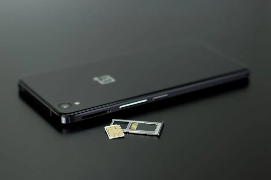 Carte SIM et tiroir SIM poses a cote d'un smartphone noir, illustrant le choix d'une SIM locale pour le reseau mobile en Guadeloupe