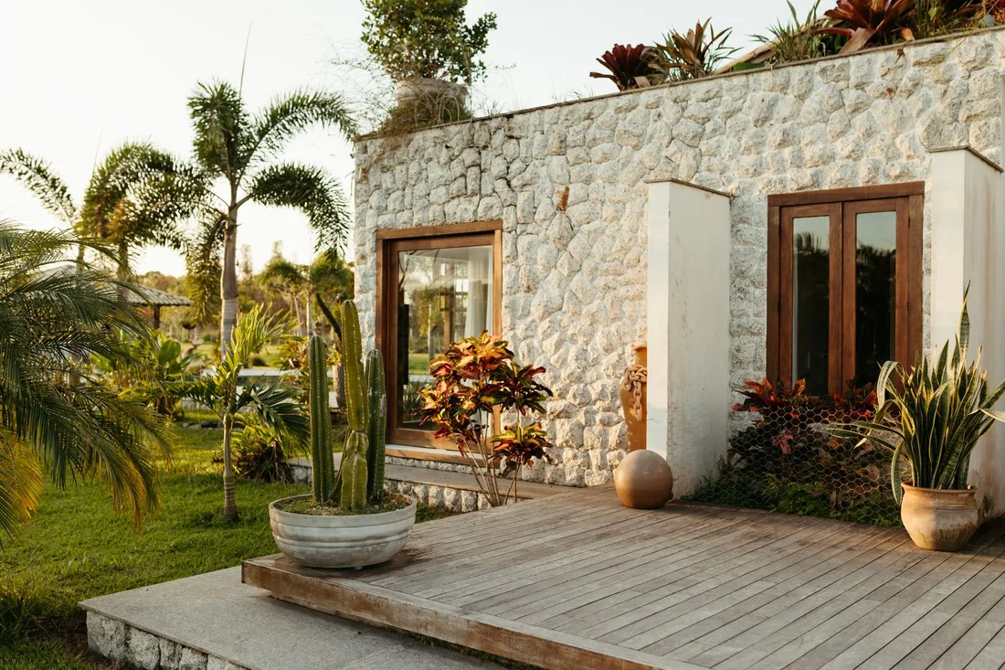 Villa à façade de pierre entourée de plantes tropicales
