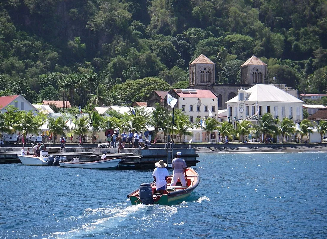 Le front de mer de Saint-Pierre en Martinique vu depuis le port, avec ses maisons, son eglise et une barque de pecheurs