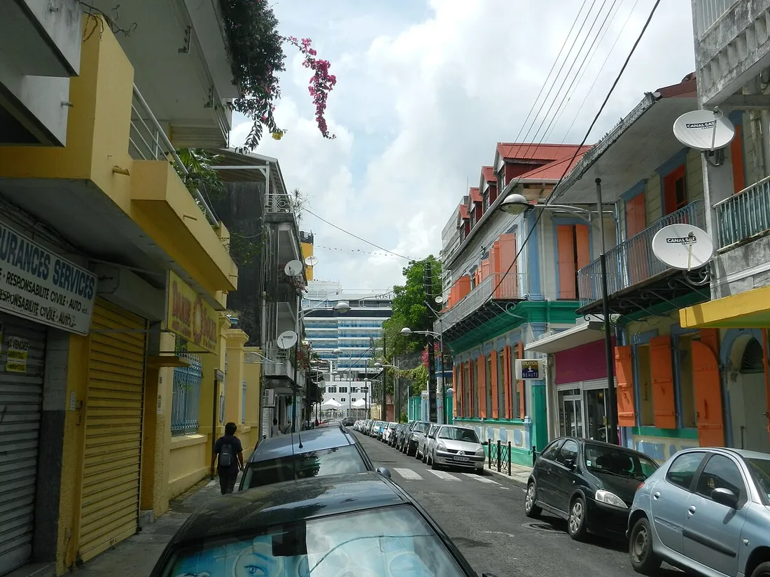 Rue commerçante de Pointe-à-Pitre en Guadeloupe bordée de maisons créoles colorées, illustrant le marché de l'immobilier locatif antillais