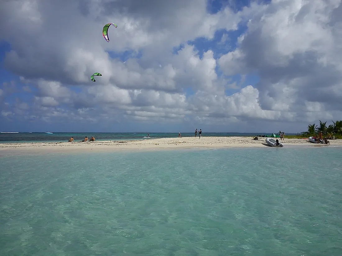 Îlet Caret, banc de sable blanc cerné d'eaux turquoise en Guadeloupe, avec un petit bateau accosté