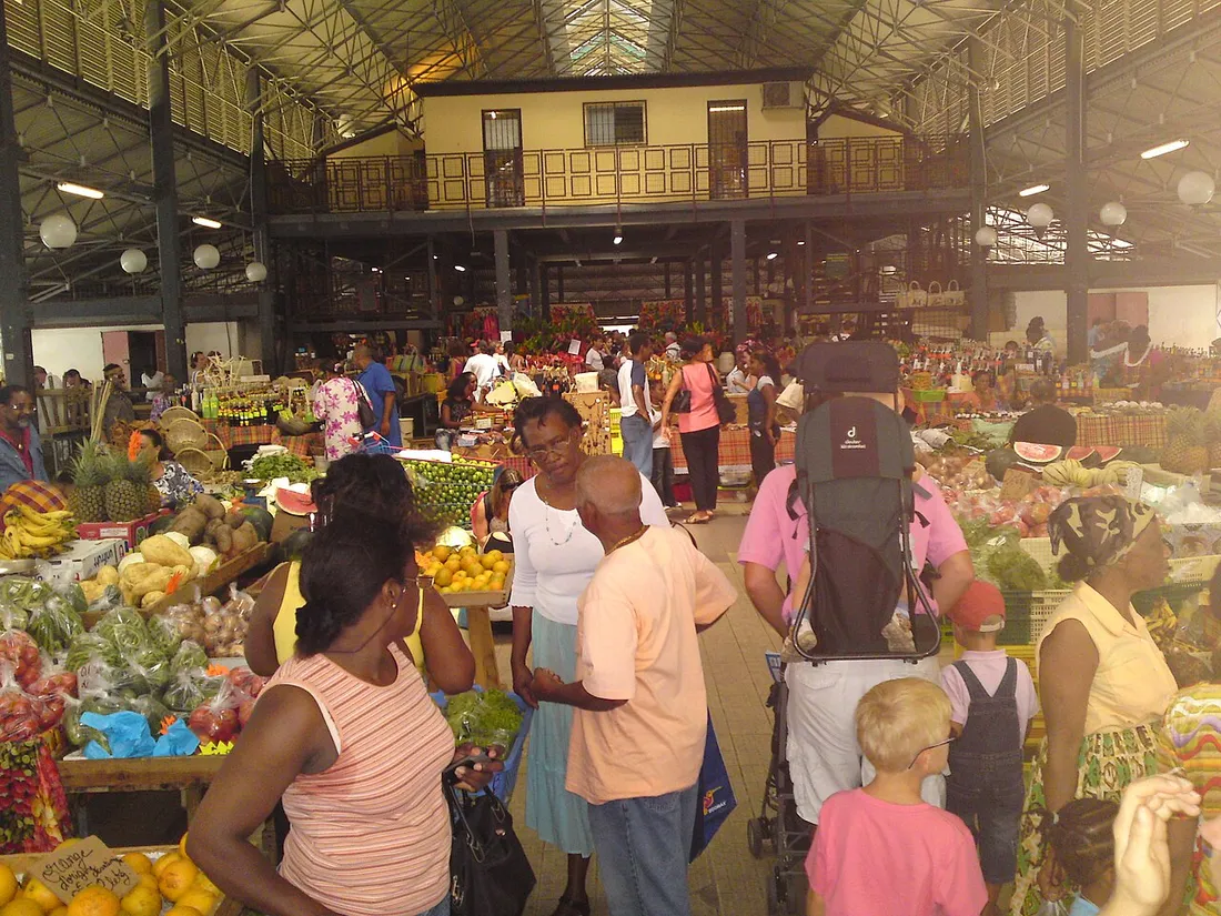 Étals de fruits et légumes tropicaux et clients au Grand Marché couvert de Fort-de-France en Martinique