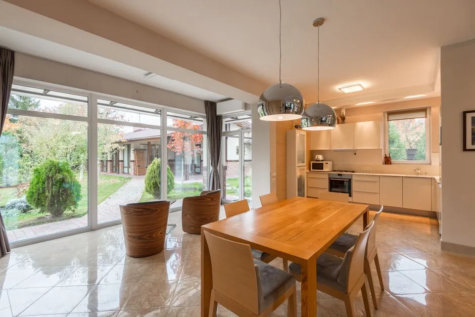 Cuisine équipée d'une villa avec four, plaque de cuisson, plan de travail et table à manger ouverte sur le jardin