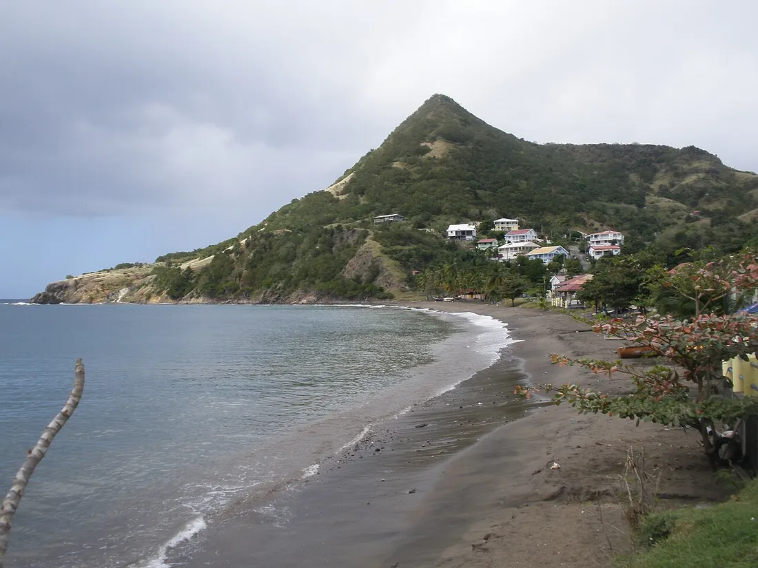 Plage et village côtier au pied d'un morne verdoyant aux Anses-d'Arlet en Martinique