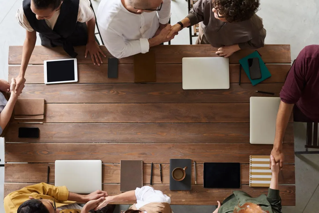 Vue de dessus d'une equipe professionnelle reunie autour d'une table de travail avec ordinateurs portables