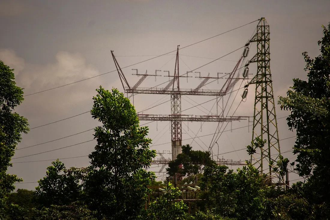 Antenne de télédiffusion TDF et pylône électrique haute tension au-dessus de la forêt à Montsinéry-Tonnegrande, en Guyane