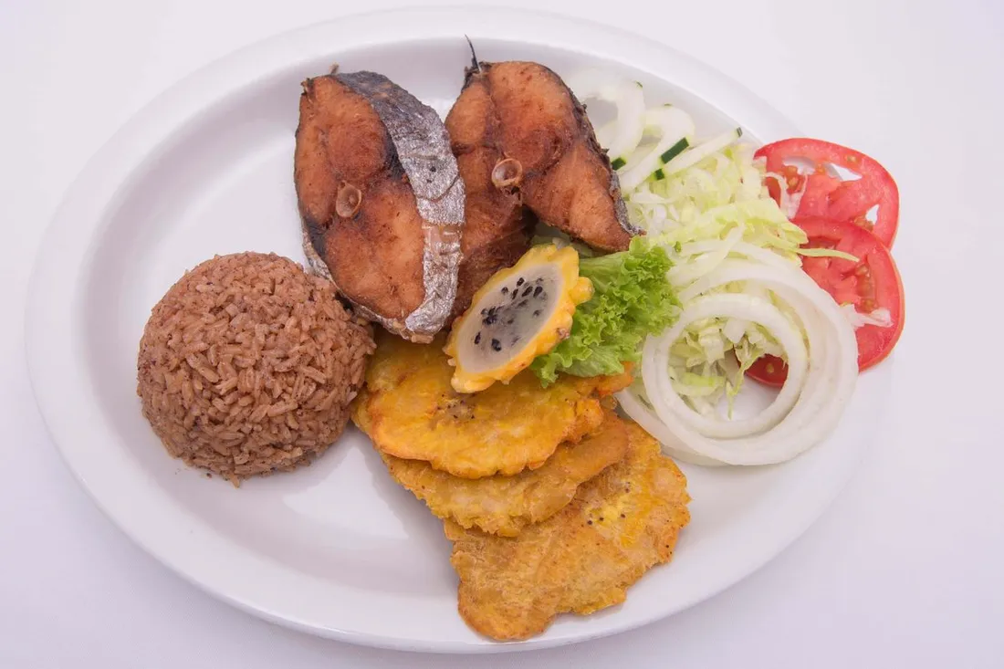 Assiette créole d'un lolo : poisson frit, riz, bananes plantain frites (tostones) et crudités