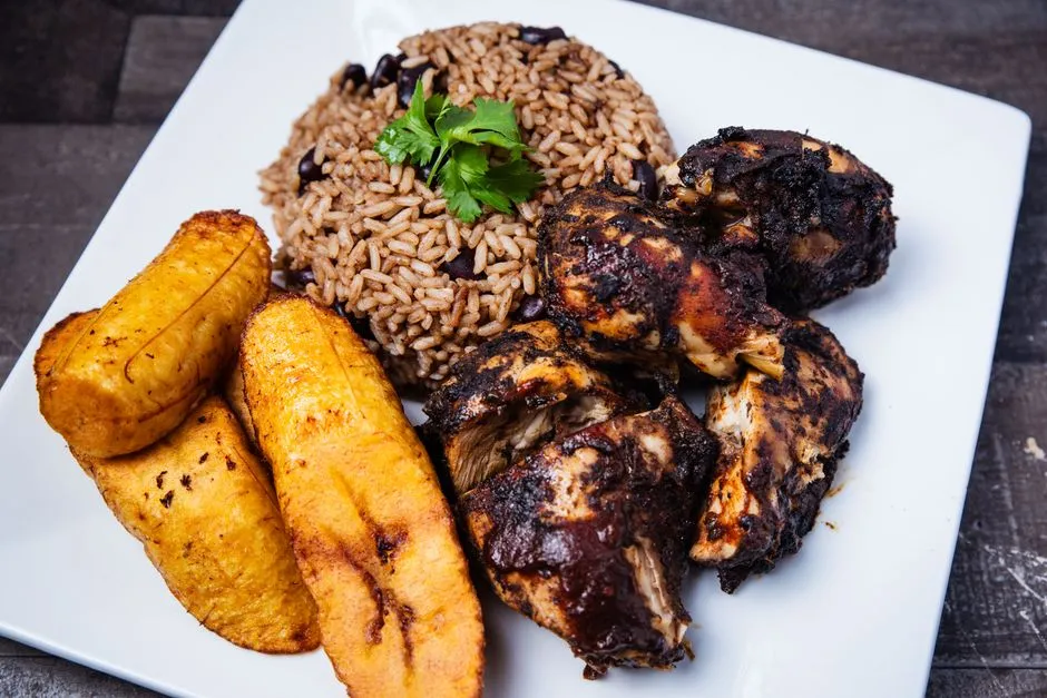 Assiette de cuisine créole antillaise avec poulet boucané, riz aux haricots rouges et bananes plantain frites