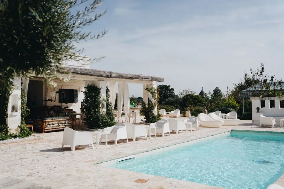 Villa privatisable avec piscine et terrasse aménagée de fauteuils blancs et de salons pour un événement en plein air