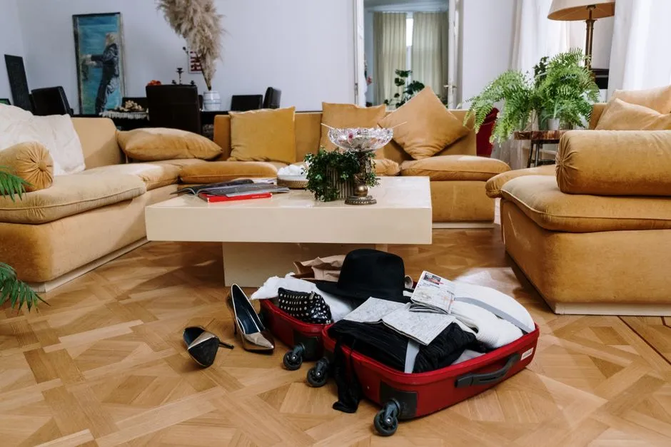 Valise ouverte posée au sol dans le salon meublé et équipé d'un logement de courte durée