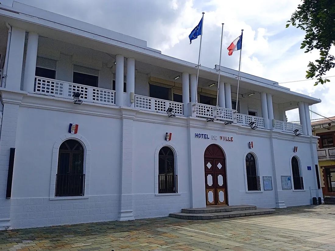 Façade de l'hôtel de ville de Sainte-Rose en Guadeloupe avec les drapeaux français et européen, lieu de déclaration des meublés de tourisme en mairie