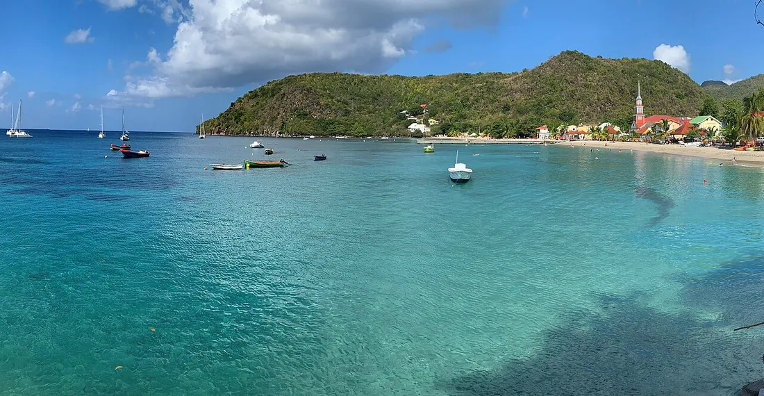Village balnéaire des Anses-d'Arlet en Martinique, église en bord de plage et bateaux sur une eau turquoise