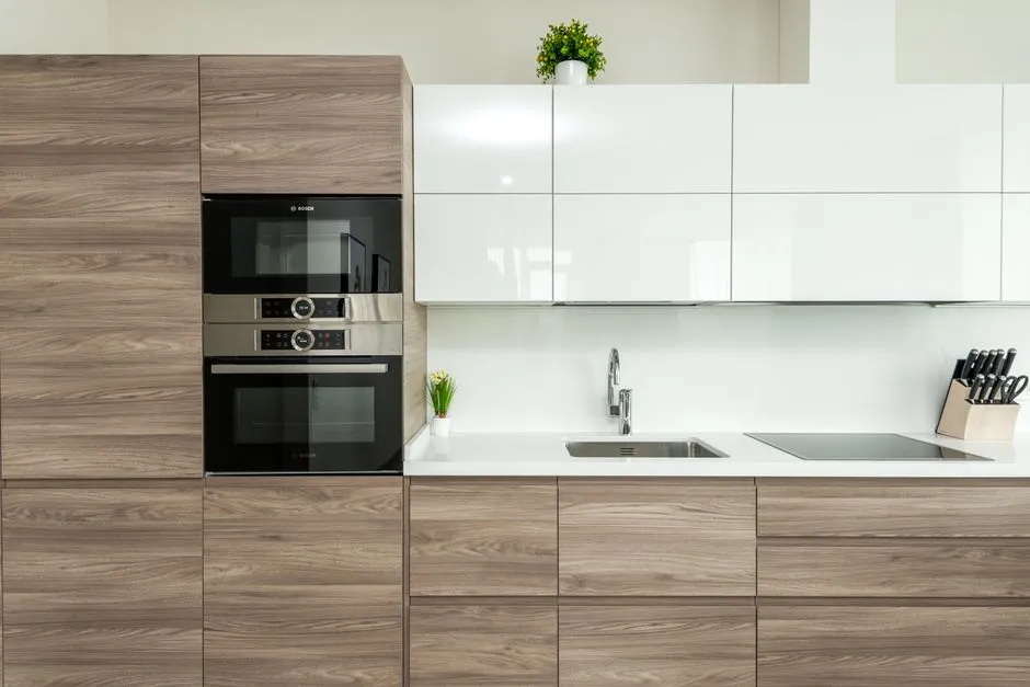 Cuisine entierement equipee d'un logement meuble avec four, micro-ondes, plaque a induction, evier et bloc a couteaux
